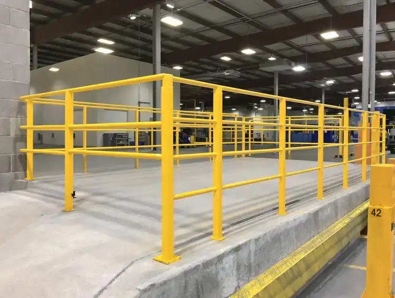 Yellow OSHA-compliant industrial safety railing along a loading dock