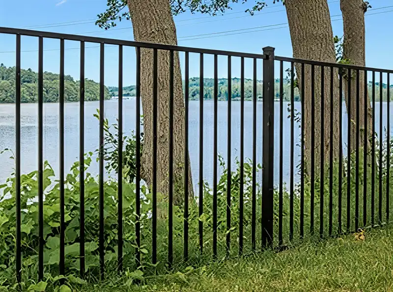 Ornamental wrought iron fence with decorative scrollwork at a residential entrance